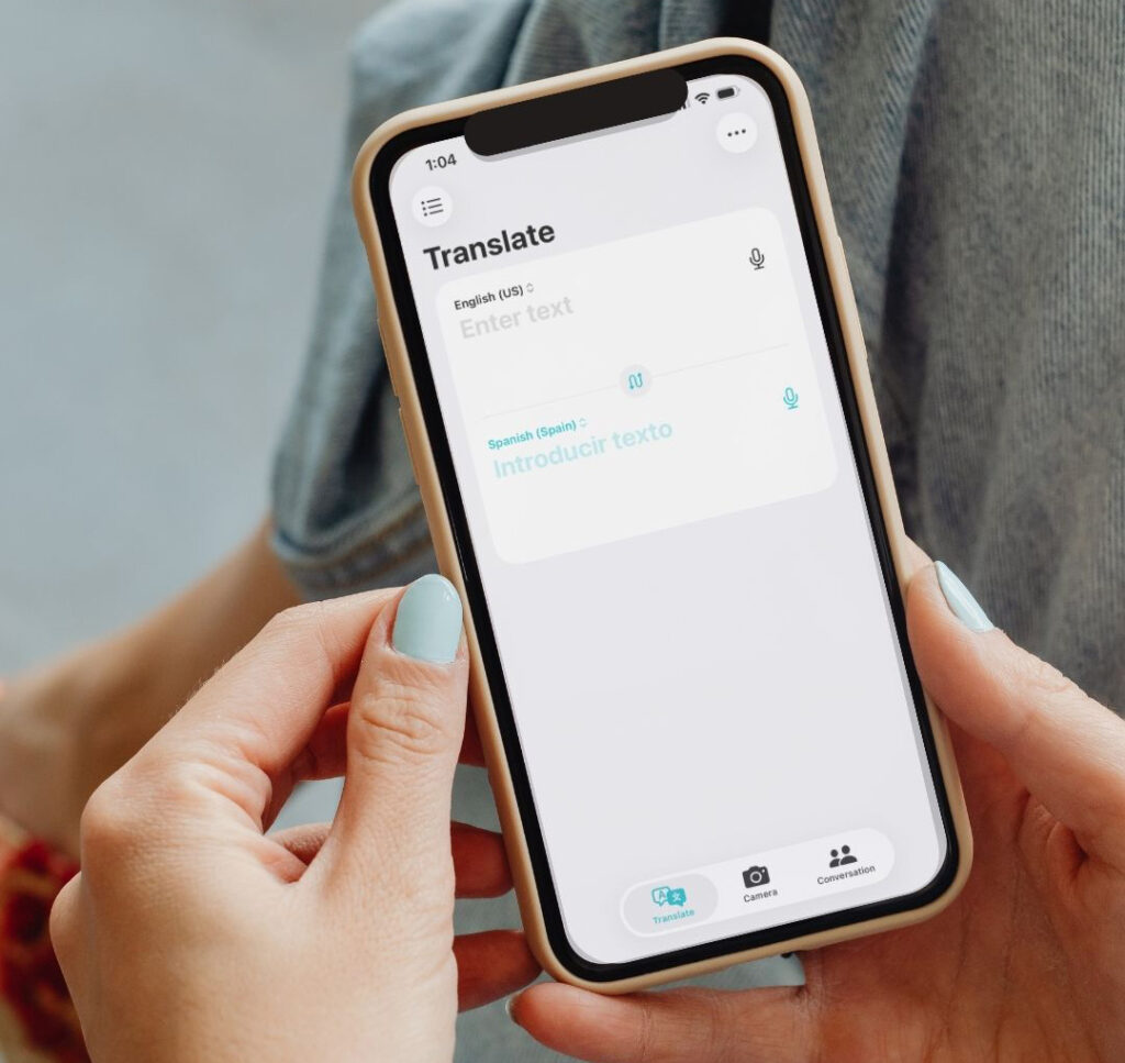 Woman holding a smart phone with the Translate app open.